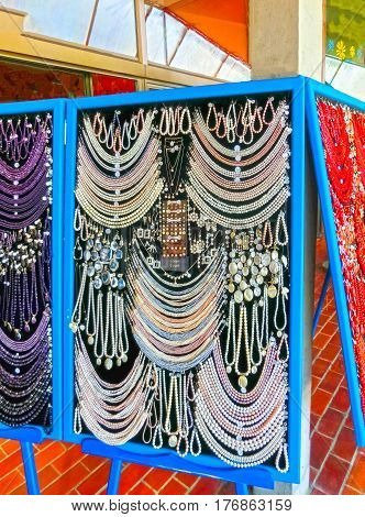 Postojna, Slovenia - May 9, 2014: Lot of colored beads from different minerals and stone background at souvenir shop at Postojna, Slovenia on May 9, 2014: