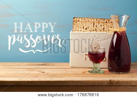 Jewish holiday Passover Pesah greeting card with wine and matzoh over wooden background