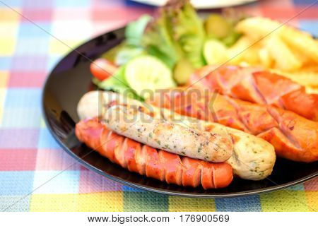 Sausage fried and french fries with vegetables on chintz.