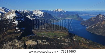 Spring day in Central Switzerland. Lake Vierwaldstattersee. Green meadows and snow capped mountains.