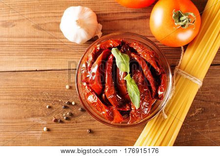 Italian spaghetti with ingredients for cooking pasta on a wooden table.