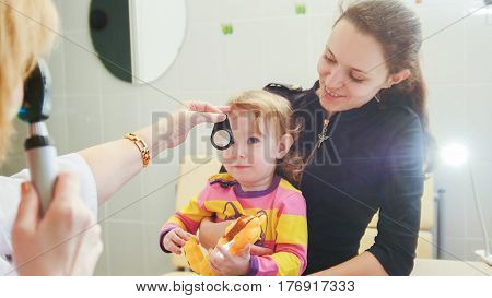 Ophthalmology - doctor checks eyesight at little girl - child's healthcare, telephoto