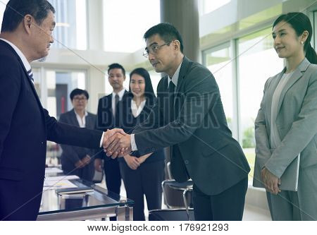 Business people greeting by handshake and take a bow