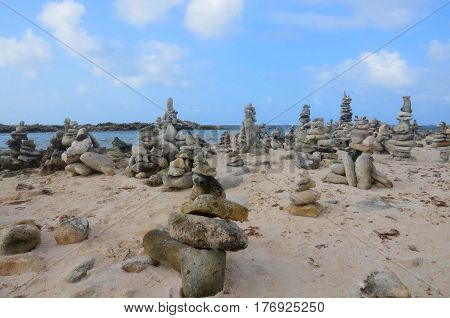 Stacked rock cairns beside the tropical waters of Aruba.