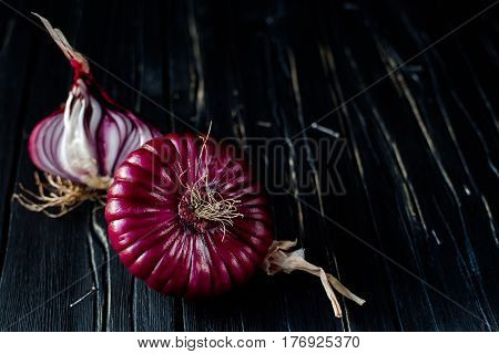 Red sliced onion on dark wooden background. close up