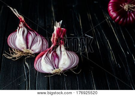 Red sliced onion on dark wooden background. close up