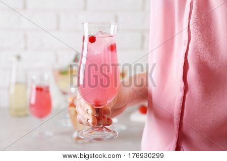 Woman holding glass of delicious wine spritzer