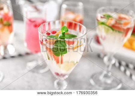 Glass of delicious wine spritzer on grey table