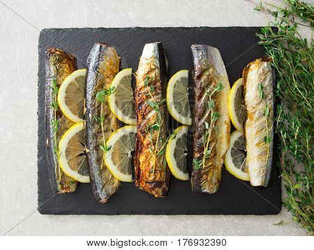 Grilled Fish Saury With Lemon On A Slate Board