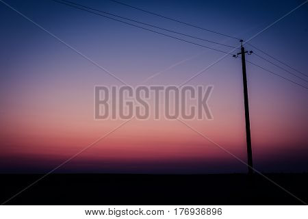 Single electric power pole on at sunrise, natural envirnomental clear energy background