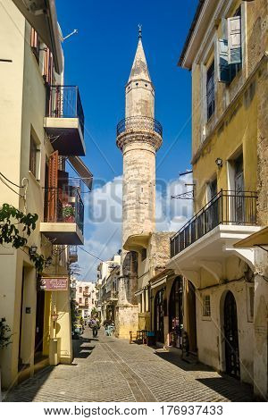 Chania, Greece - July 17, 2013: the narrow old street with a minaret and walking tourists