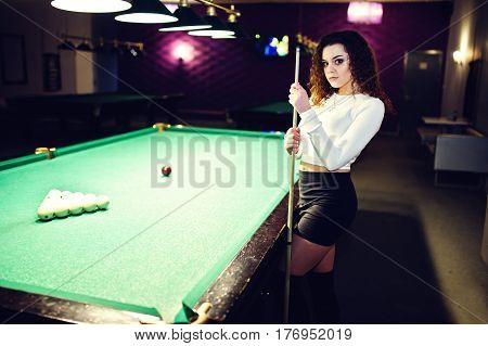 Young Curly Girl Posed Near Billiard Table. Sexy Model At Black Mini Mini Skirt Play Russian Snooker