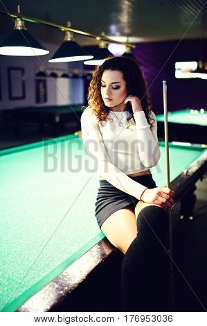 Young Curly Girl Posed Near Billiard Table. Sexy Model At Black Mini Mini Skirt Play Russian Snooker