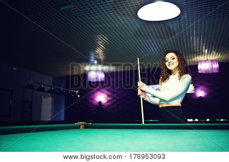 Young Curly Girl Posed Near Billiard Table. Sexy Model At Black Mini Mini Skirt Play Russian Snooker