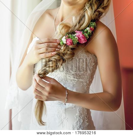 Pretty and tenderless young bride with flower decoration in her hair