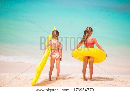 Adorable little girls have fun on white beach during vacation
