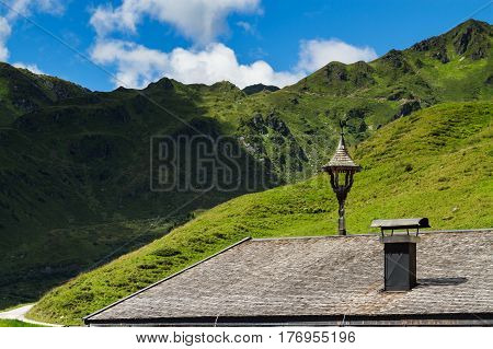 Roof of old house with view on mountains. Alpine landscape along the Zillertal high road Austria Tyrol