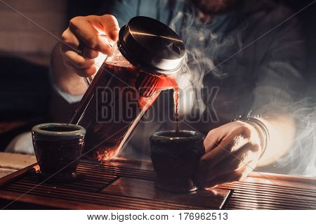 Annoyed Man, Bearded Hipster With Beard Pours Tea On The Table