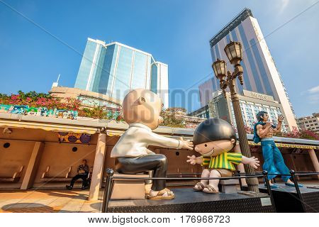 Hong Kong, China - December 5, 2016: Cowboy and Bruce Lee, statues of famous characters, Hong Kong Avenue of Comic Stars, Kowloon Park. Urban skyline of Tsim Sha Tsui District.