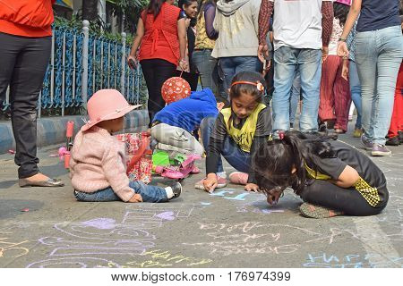 KOLKATA WEST BENGAL INDIA - FEBRUARY 7TH 2016 : City kids drawing on the street celebrating "Happy Street" event on Park Street Kolkata. Children played enjoyed and smiled all day.