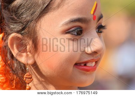 KOLKATA INDIA - MARCH 12 2017: Young girl with spring festive make up with flowers joyful expression at Holi/Spring festivalknown as Dol (in Bengali) or Holi (in Hindi) celebrating arrival of Spring in India.