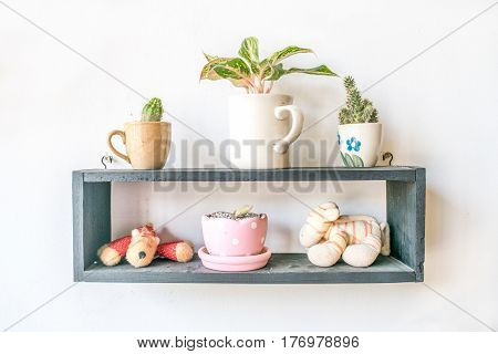small doll and  small plant in pot decoration on wood frame isolated white background