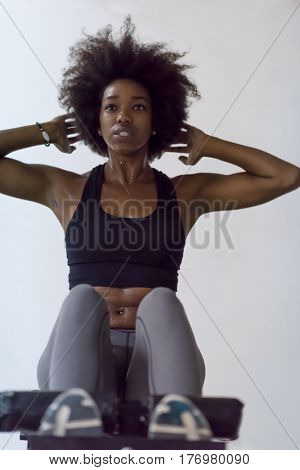 young fit african american woman doing sit ups in fitness studio at the gym.Abdominal exercises Sit up