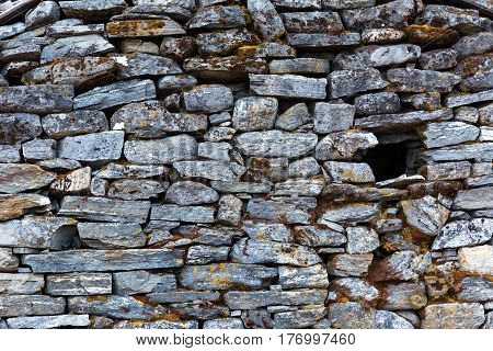 Stone Wall of rural Building made with manual work without linking solution of small pieces of rocks carefully tailored to each other