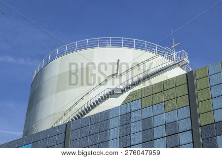 Industry Park In Frankfurt Hoechst With Tank And Noise Protection Wall  Under Blue Sky