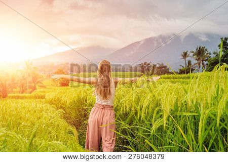 Young Woman Traveler On Beautiful Jatiluwih Rice Terraces Against The Background Of Famous Volcanoes