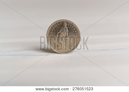 Back Of A 1 Chf Swiss Franc Coin Standing On A Table