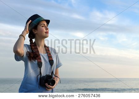 Girl With A Camera On A Blue Sea Background.
