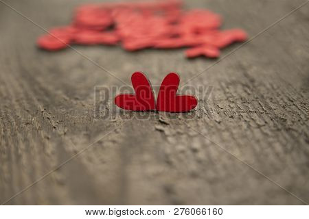 Two Wooden Red Hearts On An Old Dry Wooden Board For Valentines Day Close-up. In The Background Are 