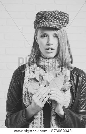 Fashion Model With Stylish Hair In Hat. Woman With Autumn Leaves In Leather Jacket. Beauty And Fashi