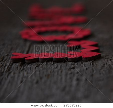 The Word Love Is Laid Out With Small Red Hearts On An Old Dry Blackboard Close-up