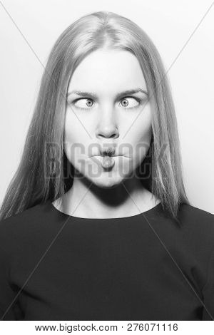 Woman Squinting Eyes On Funny Face. Young Woman With Crossed Grey Eyes, Healthy Skin And Long Blond 