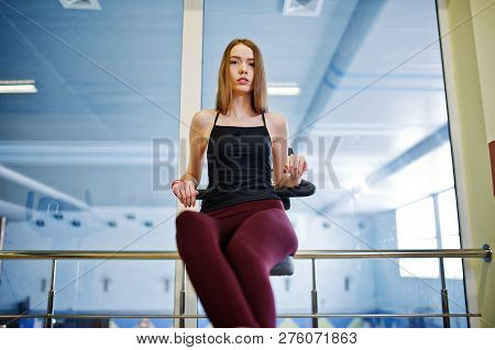 Young Sport Girl Workout In Gym. Fitness Woman Doing Exercises On Stationary Bicycle.