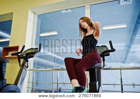 Young Sport Girl Workout In Gym. Fitness Woman Doing Exercises On Stationary Bicycle.