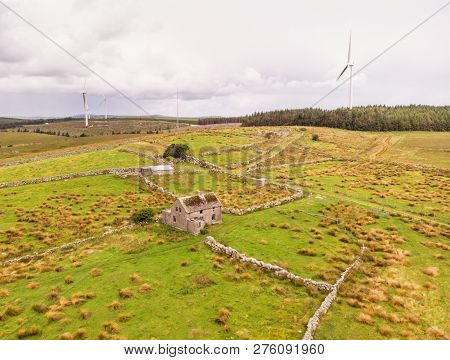An Aerial View Of  Wind Turbines And An Abandoned Farm House Between The Towns Of Spiddal And Moycul