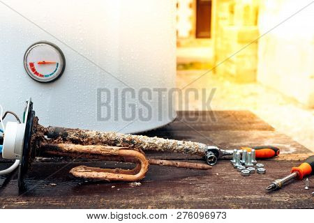 Disassembled Water Heating Tank On Wooden Background With Copy Space.