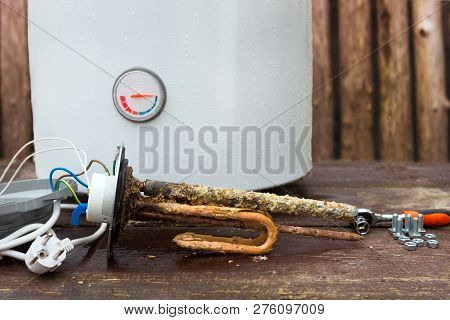 Broken Water Heater With Heating Elements, On Wooden Background.