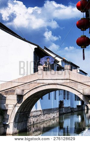 A Chinese Woman Wearing A Black And White Stripped Shirt And Holding An Umbrella On A Stone Bridge I