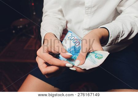 Russian Rubles In The Hand Of A Fan.male Hand Holding Many Of The Russian Banknotes.the Transfer Of 