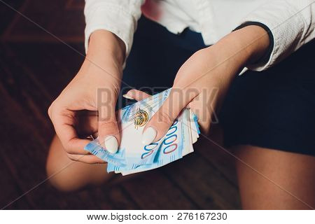 Russian Rubles In The Hand Of A Fan.male Hand Holding Many Of The Russian Banknotes.the Transfer Of 