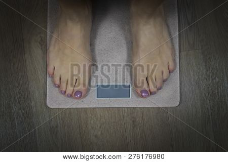 Diet And Fitness Concept. Close Up To Female Bare Feet With Pedicure Standing On Scales With Empty D