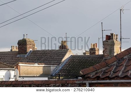 Northern Town Tiled Roof Tops With Chimneys And Aerials Uk. Cramped Urban Working Class Housing. Old