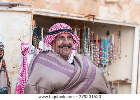 Al Jaya, Jordan, December 06, 2018 : The Seller - An Arab Stands Near His Shop With Souvenirs Near T