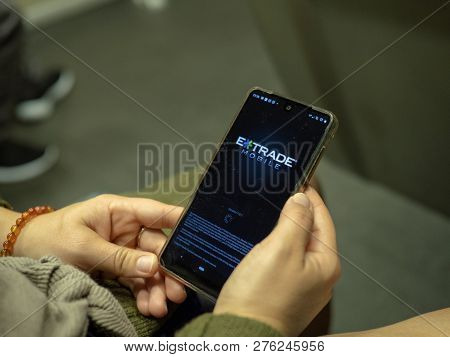 San Francisco, Ca October 6, 2018: Woman Opening E-trade Mobile App With Logo On Android Screen Whil