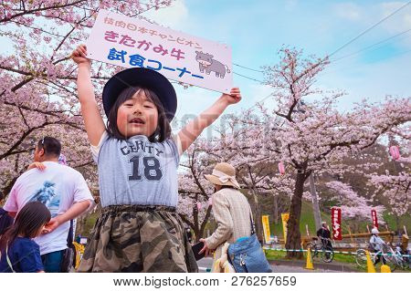 Iwate , Japan - April 22 2018: Unidentified Young Japanese Girl Holds Sign Selling The Kitakami Beef