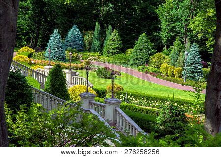 Stairs With Stone Railings Balusters And Iron Lanterns On The Background Of The Park With A Luxuriou